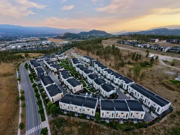 Aerial view of Academy Ridge at sunset, with the Okanagan Valley and mountains beyond