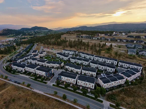 Aerial view of Academy Ridge townhomes at golden hour, sun setting over the mountains